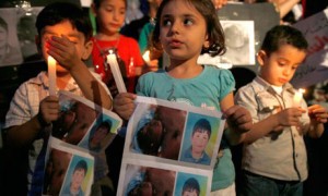 Syrian children hold a vigil for 13-year-old Hamza al-Khatib, who activists say was tortured and killed by Syrian security forces. Photograph: Jamal Saidi/Reuters